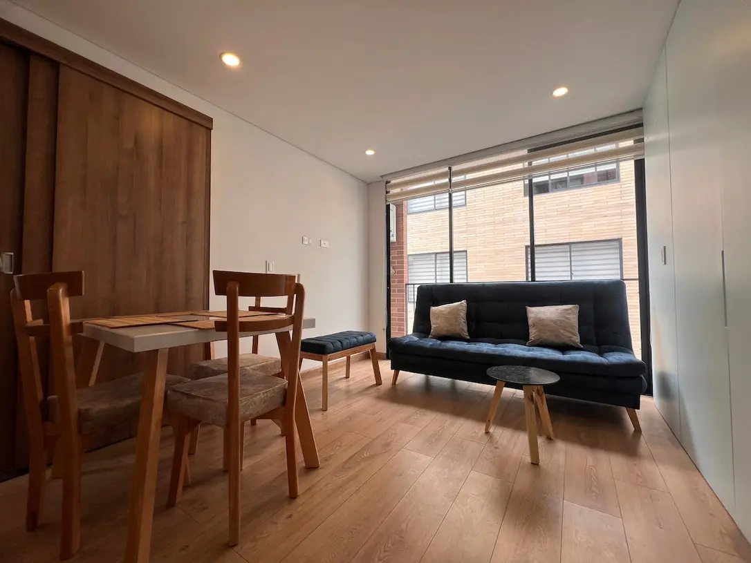 Sala comedor del apartamento 301 con sofa, mesa y ventanal