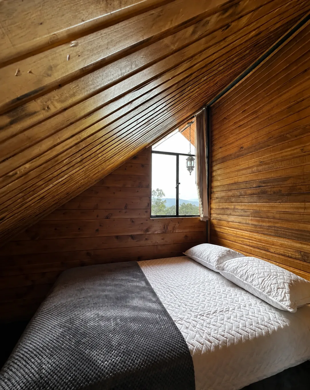 Primera habitacion de Casa Neusa, bajo el techo de madera inclinado