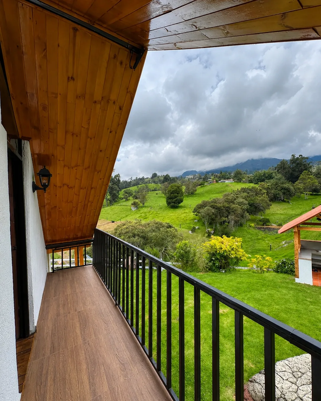Balcon de madera de Casa Neusa con vista al paisaje verde y a las montanas