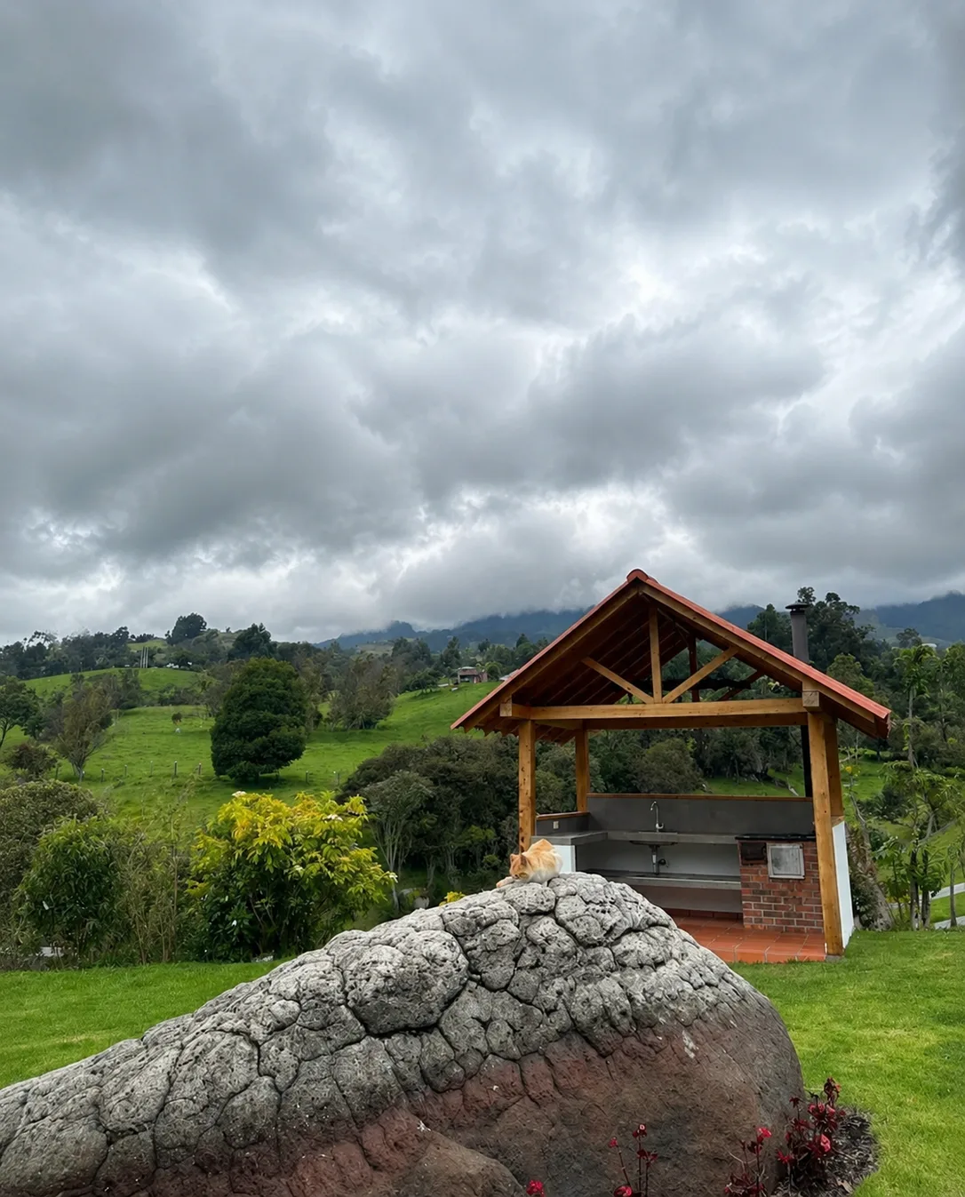 Zona de BBQ de Casa Neusa, con estructura de madera techada sobre el cesped