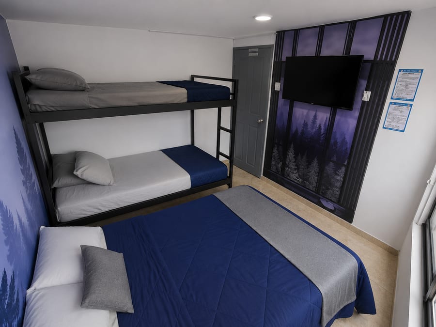 Televisión de la habitación 202 frente a la cama doble y el camarote