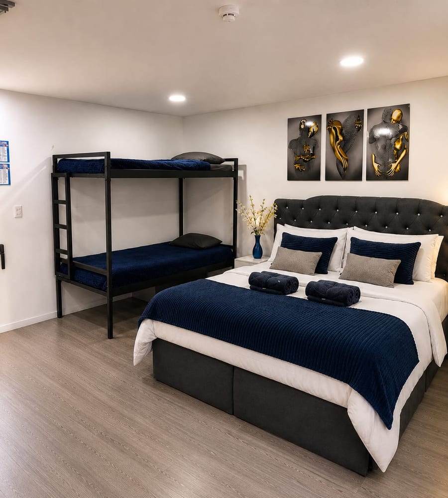 Habitacion de la Suite 301 con cama doble, camarote de dos camas y ropa de cama azul y blanca