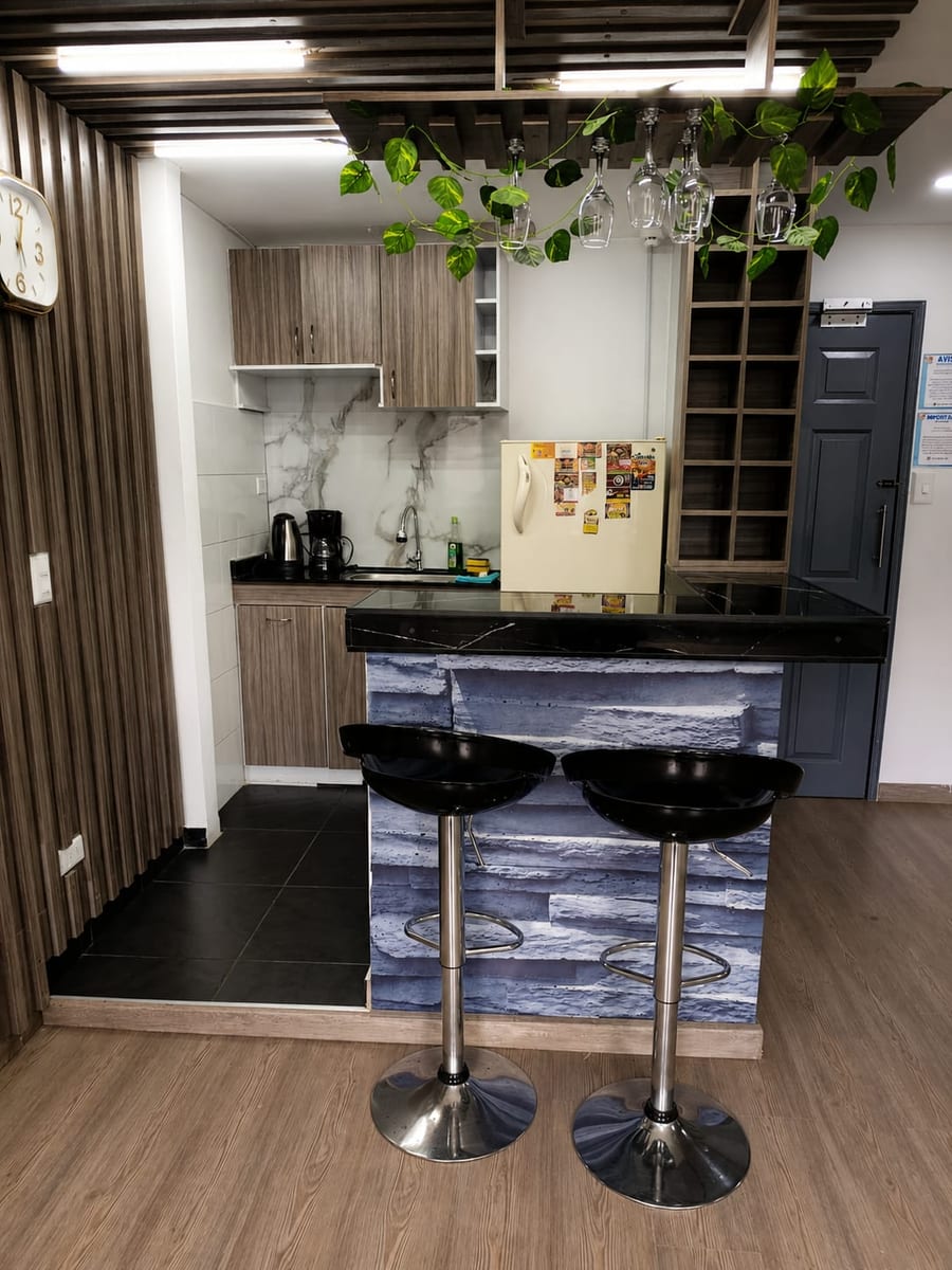 Cocina equipada de la Suite 301 con barra, taburetes altos y nevera